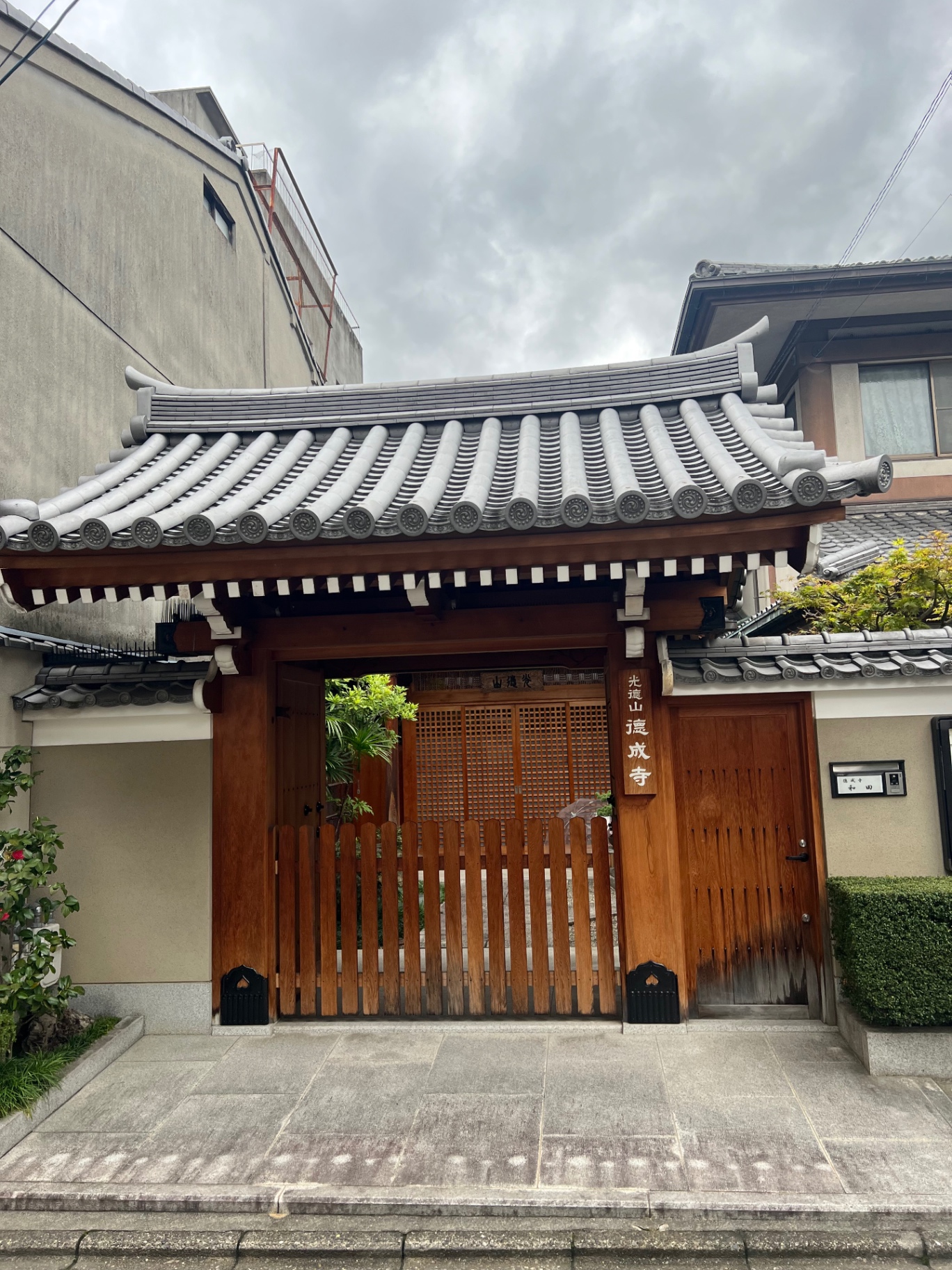 Hölzernes Tempeltor mit grauem Ziegeldach in einem Wohnviertel von Kyoto