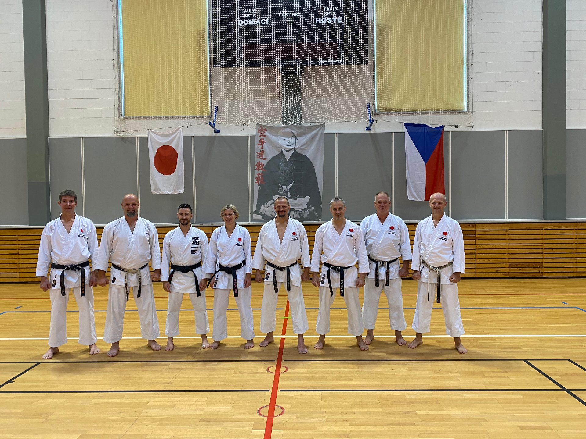 Gruppenbild vor dem Funakoshi-Porträt mit japanischer und tschechischer Flagge